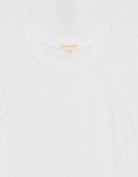 Close-up of a white t-shirt with exposed unsubscribed brand tag on a white background